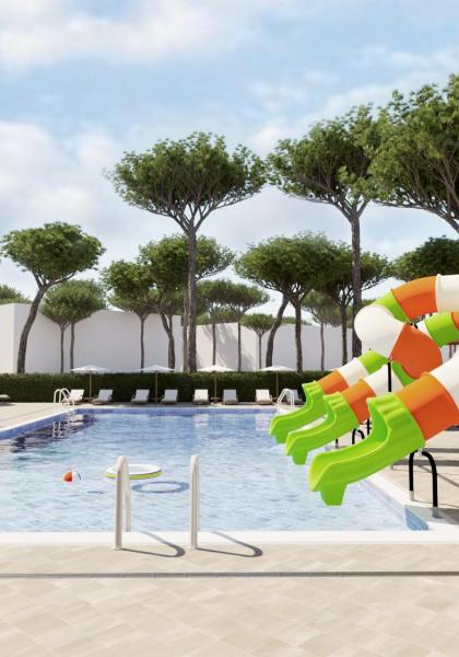 Piscina con scivoli colorati e lettini sotto gli alberi.