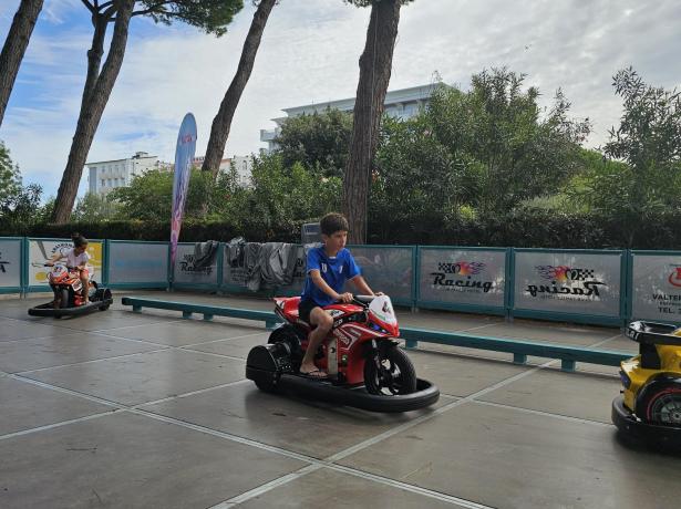 Bambini guidano moto giocattolo in un parco divertimenti.