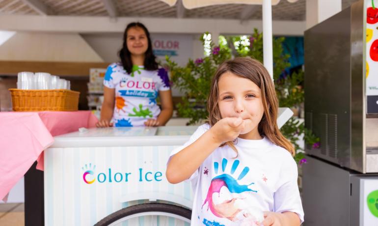 Enfant mangeant une glace au stand Color Ice.