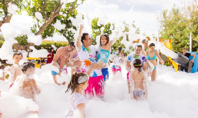 Schaumparty im Freien mit Kindern und Erwachsenen, die Spaß haben.