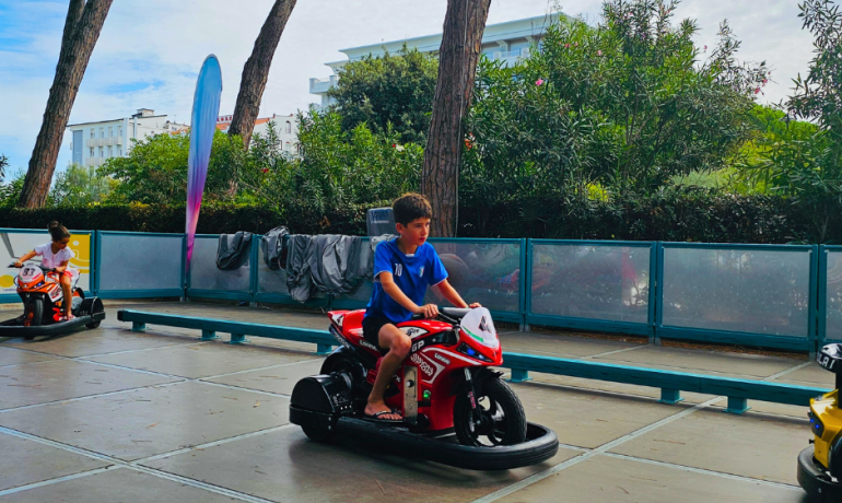 Bambini su moto giocattolo in un parco giochi all'aperto.