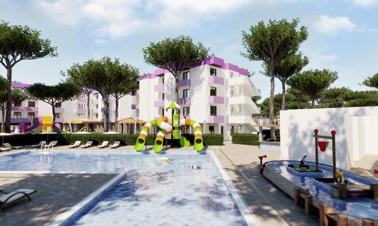 Pool mit bunten Rutschen und Wohnungen im Hintergrund.