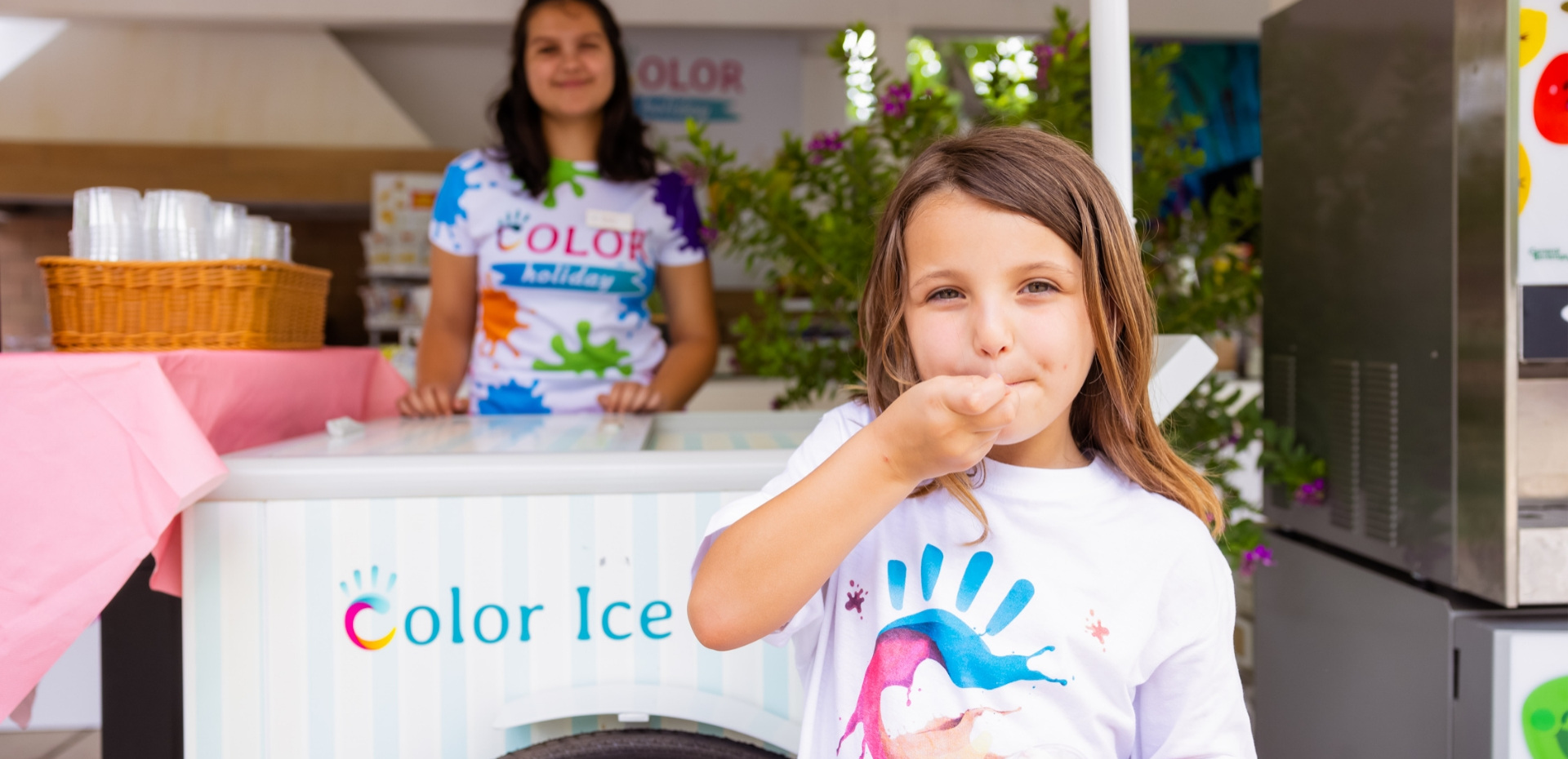Happy girl eating ice cream, smiles and vibrant colors around.