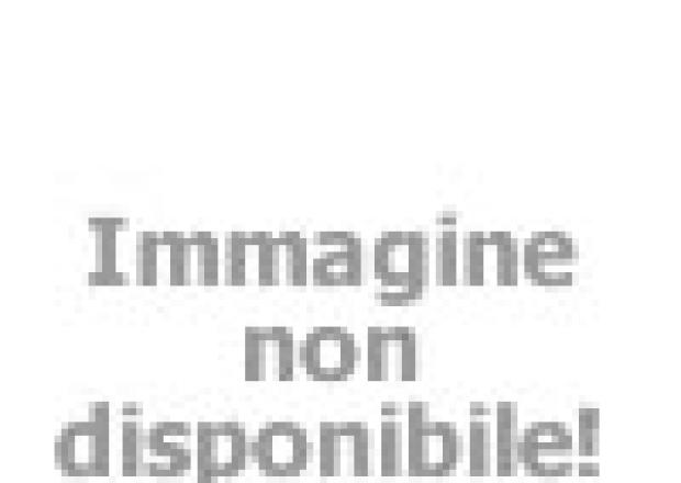Persone si divertono in una piscina per bambini all'aperto con giochi d'acqua.