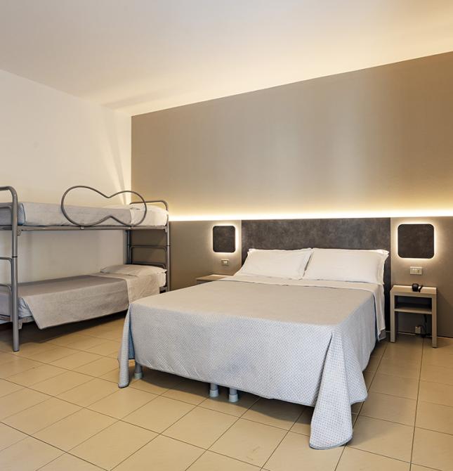 Chambre accueillante avec lit double et lits superposés, ambiance reposante.