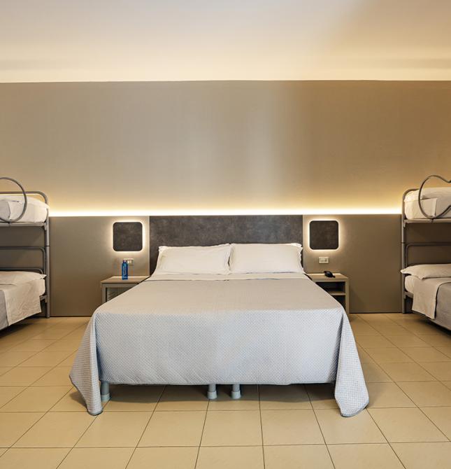 Chambre accueillante avec lit double et lits superposés, ambiance relaxante.