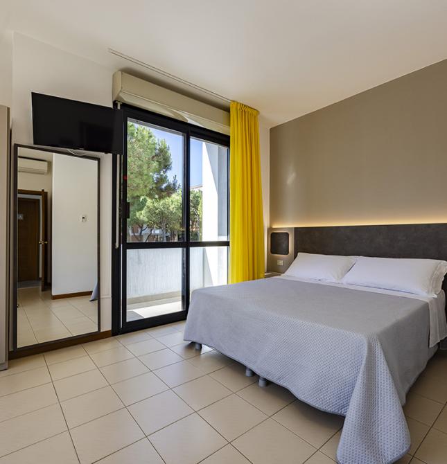 Chambre lumineuse avec lit superposé et rideaux jaunes, ambiance chaleureuse.
